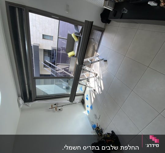 תריסים פתוחים ליד חלון זכוכית גדול